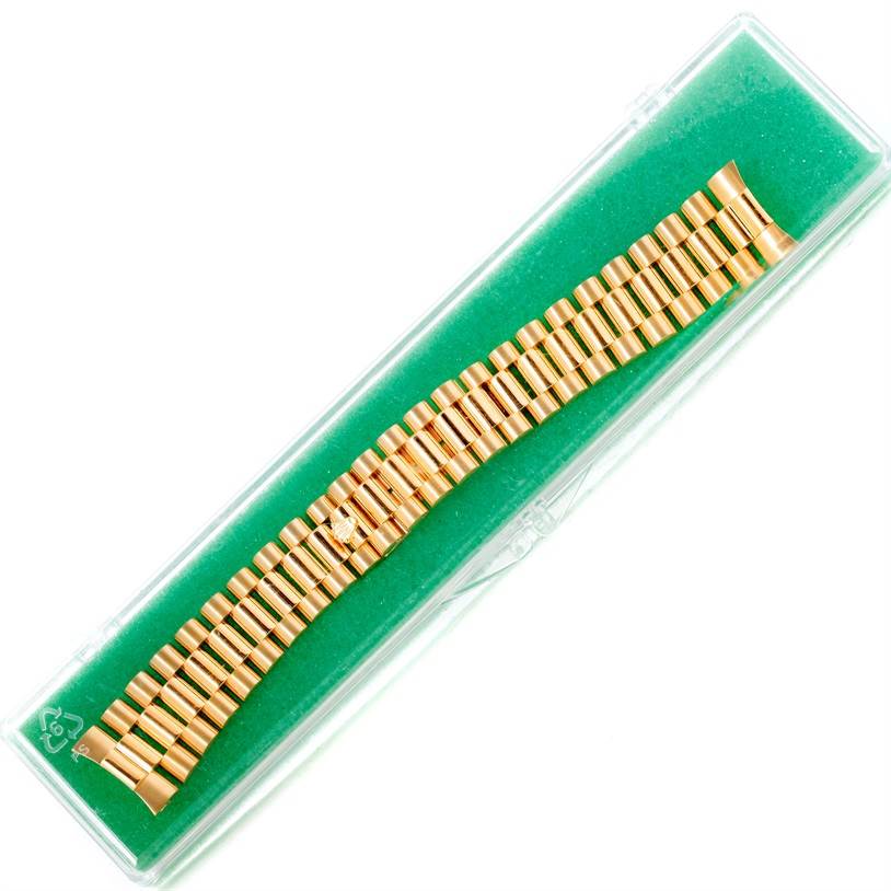This image shows a gold bracelet for a President model Rolex watch in a protective case, viewed from above.