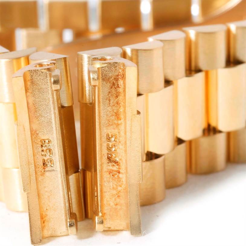 This image shows a close-up of the Rolex President Men's  Men's  model's gold bracelet links from a side angle.