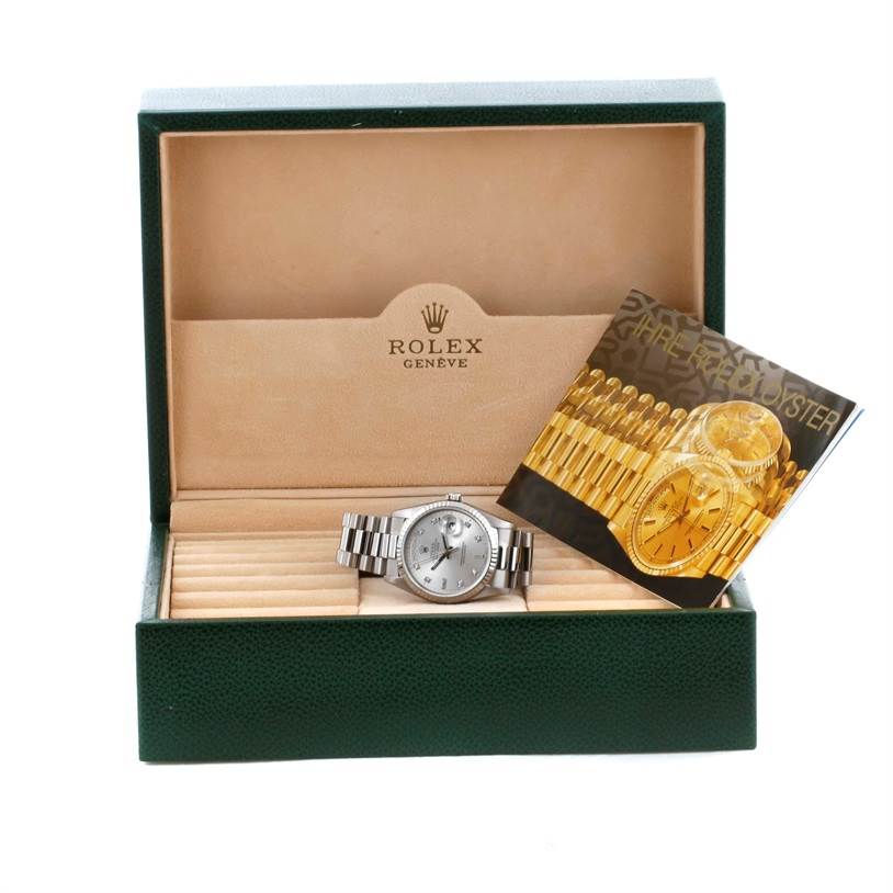 The image shows a Rolex President 18239 Men
s White Gold Silver Dial 18239 Men
s White Gold Silver Dial model watch in its box, alongside an informational booklet.