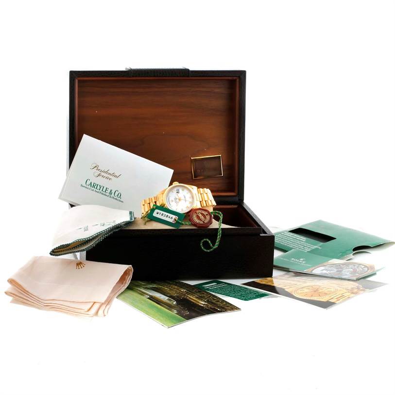 The Rolex President 18238 Men's Yellow Gold White Dial 18238 Men's Yellow Gold White Dial model watch is shown at an angled view inside an open box, accompanied by documents and a cloth.