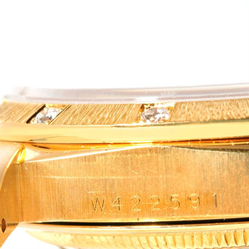 This close-up image shows part of the gold watch case and diamond bezel of a Rolex President 18308 Men's Yellow Gold White Dial 18308 Men's Yellow Gold White Dial model, including a serial number.