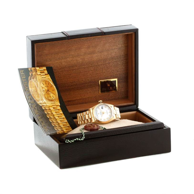The Rolex President 18038 Men's Yellow Gold White Dial 18038 Men's Yellow Gold White Dial model watch is shown inside a wooden box, accompanied by its manual and a tag.