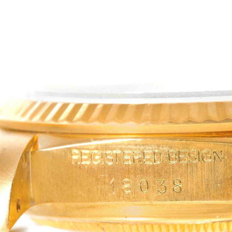 The image shows a close-up angle of the side of a Rolex President 18038 Men's Yellow Gold White Dial 18038 Men's Yellow Gold White Dial model watch, highlighting the case and the "REGISTERED DESIGN" engraving.