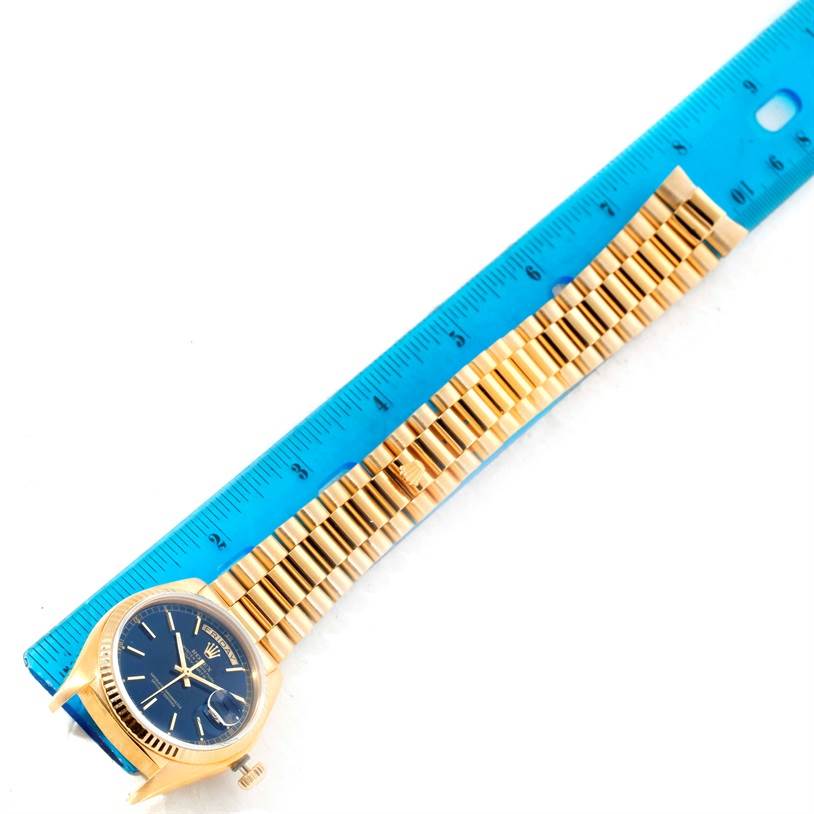 The image shows a Rolex President 18038 Men's Yellow Gold Blue Dial 18038 Men's Yellow Gold Blue Dial model watch displayed next to a blue ruler for scale, featuring its face and bracelet.