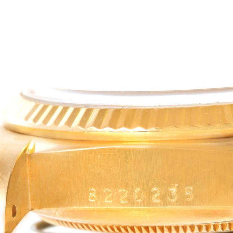 The image shows a close-up side view of a Rolex President 18038 Men
s Yellow Gold Champagne Dial 18038 Men
s Yellow Gold Champagne Dial model watch, focusing on the fluted bezel and engraved case number.