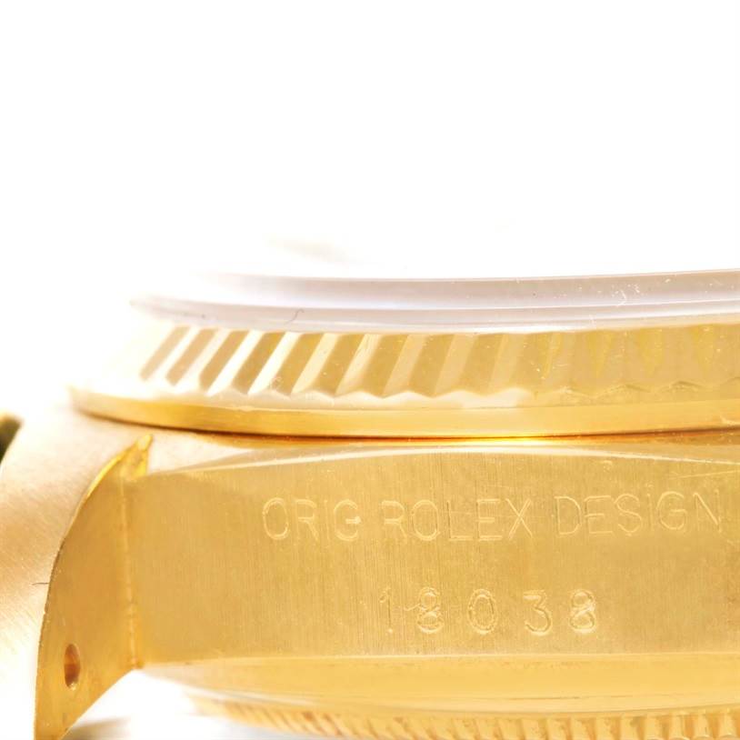 This close-up angle shows the side of a Rolex President 18038 Men
s Yellow Gold Champagne Dial 18038 Men
s Yellow Gold Champagne Dial model, highlighting the "ORIG ROLEX DESIGN" inscription and part of the bezel.