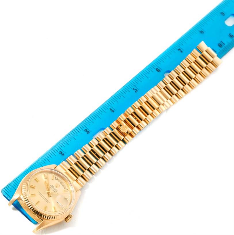 This image shows a Rolex President 1803 Men
s Yellow Gold Champagne Dial 1803 Men
s Yellow Gold Champagne Dial watch laid flat alongside a ruler, displaying its face and bracelet.