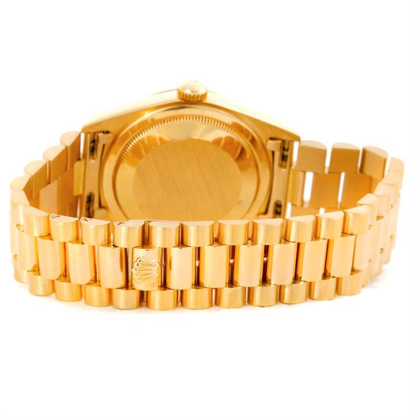 The image shows the back view of a Rolex President 18238 Men
s Yellow Gold Champagne Dial 18238 Men
s Yellow Gold Champagne Dial model watch, displaying its case back and gold bracelet.