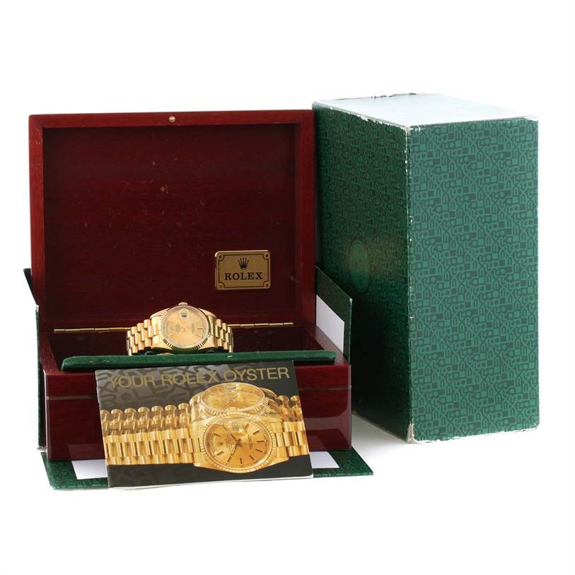 The image shows a Rolex President 18238 Men
s Yellow Gold Champagne Dial 18238 Men
s Yellow Gold Champagne Dial model watch inside its box, along with accompanying documents and outer packaging.