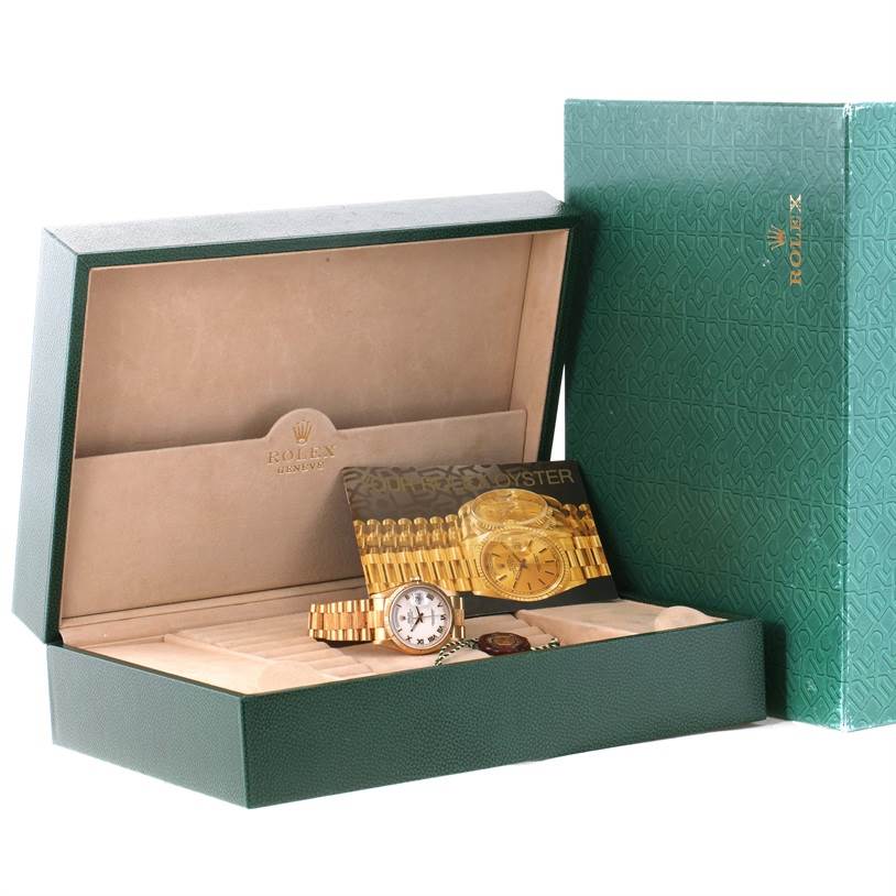 This image shows the Rolex President 18248 Men's Yellow Gold White Dial 18248 Men's Yellow Gold White Dial watch with its box and related accessories, including a booklet and extra links.