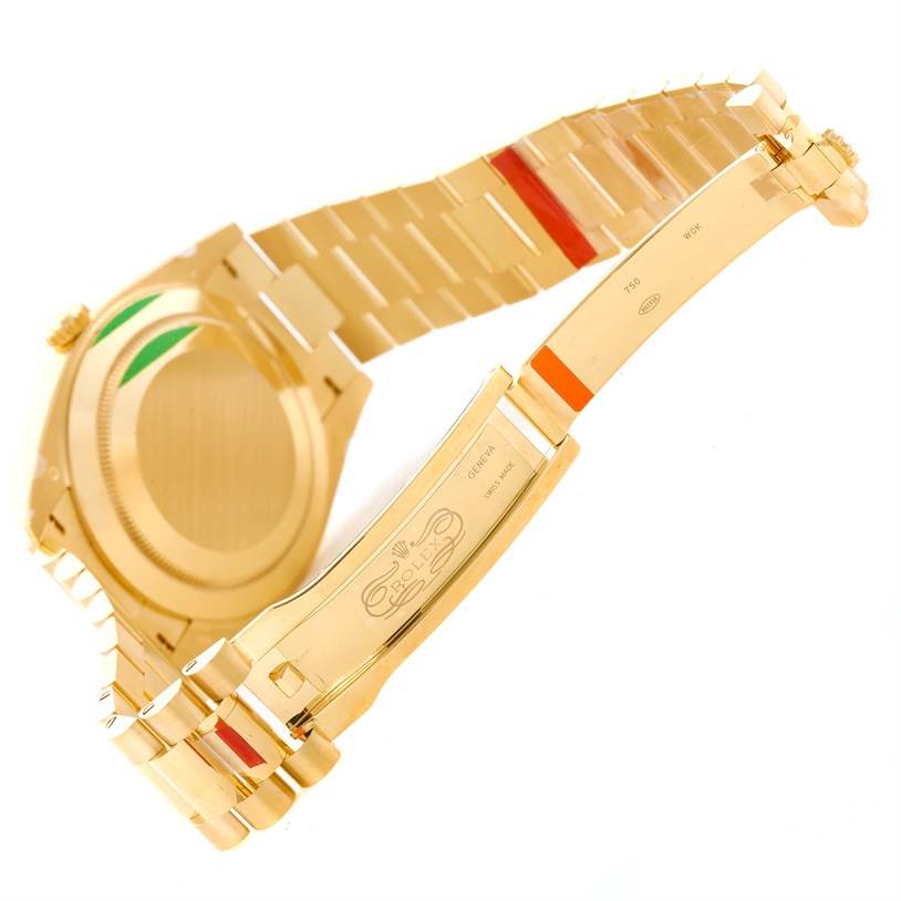 The image shows the back and inner clasp of a Rolex President 228238 Men's Yellow Gold Silver Dial 228238 Men's Yellow Gold Silver Dial model watch, displaying part of the bracelet and its inscriptions.