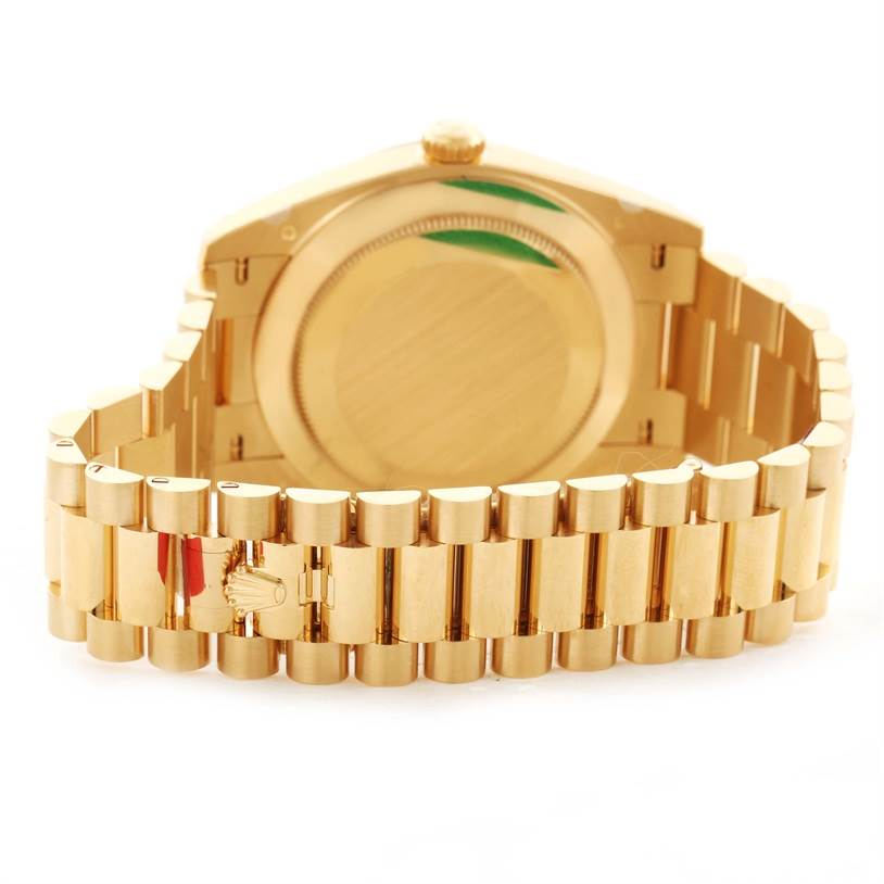 The image shows the back and bracelet clasp of a Rolex President 228238 Men's Yellow Gold Silver Dial 228238 Men's Yellow Gold Silver Dial watch in a gold color.