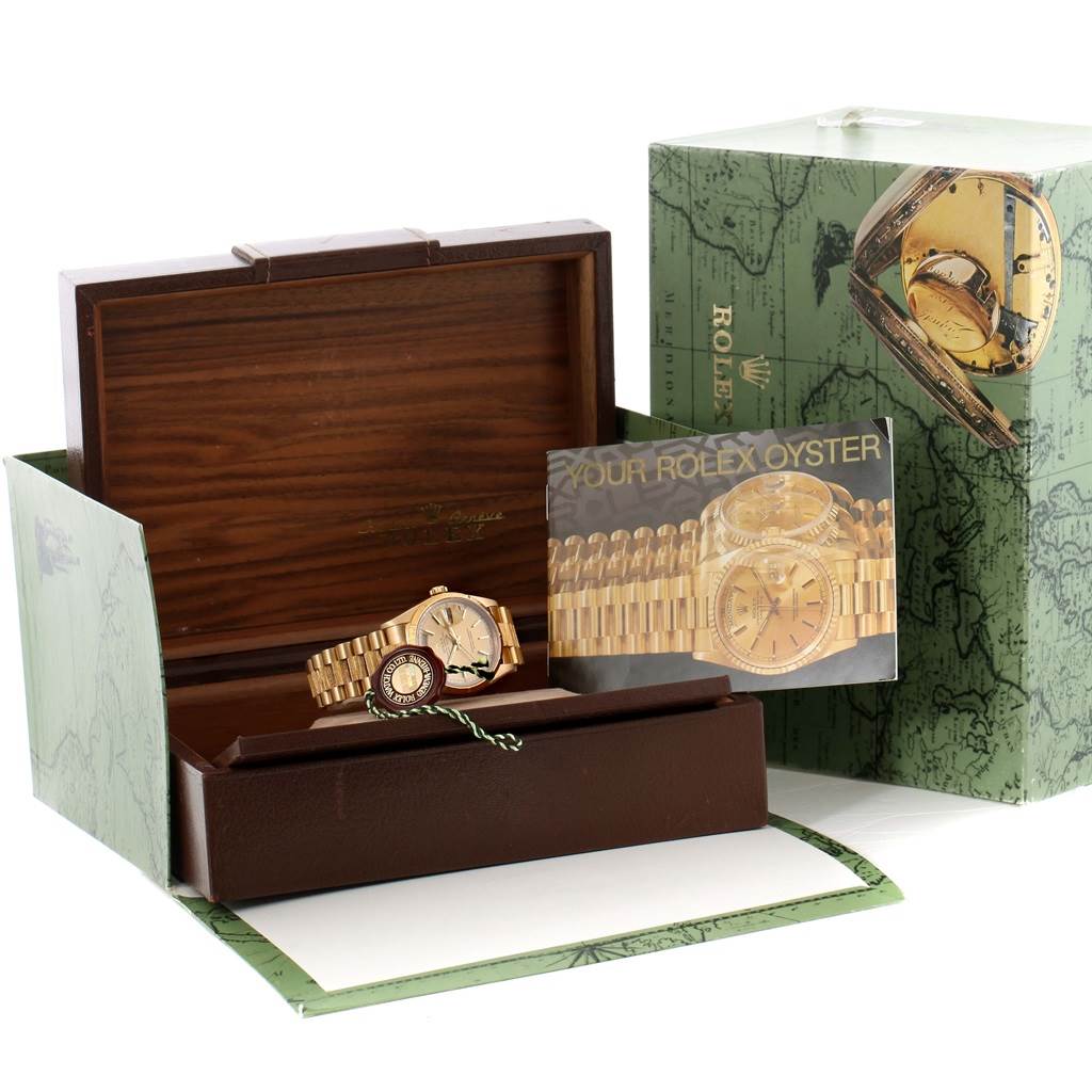 The image shows a Rolex President 18248 Men
s Yellow Gold Champagne Dial 18248 Men
s Yellow Gold Champagne Dial model watch and its packaging, including its box, manual, and outer box displayed at an angle.