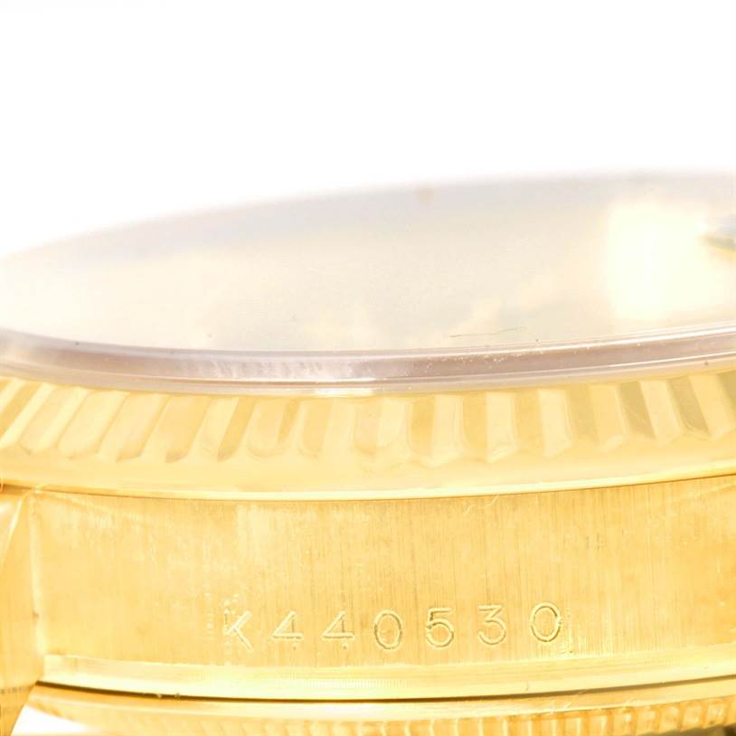 The image shows a close-up of the side of the Rolex President 118238 Men
s Yellow Gold Black Dial 118238 Men
s Yellow Gold Black Dial model, highlighting the bezel and serial number on the case.