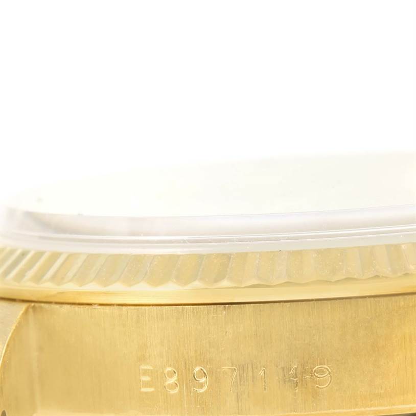This image shows a close-up of the side of a Rolex President 15238 Men
s Yellow Gold Silver Dial 15238 Men
s Yellow Gold Silver Dial watch, focusing on its bezel and part of the case with engraved numbers.