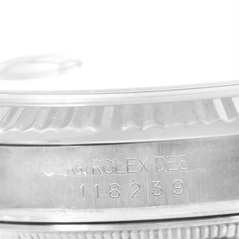 This image shows a close-up of the Rolex President 118239 Men's White Gold Silver Dial 118239 Men's White Gold Silver Dial model's bezel and case, displaying its serial number.