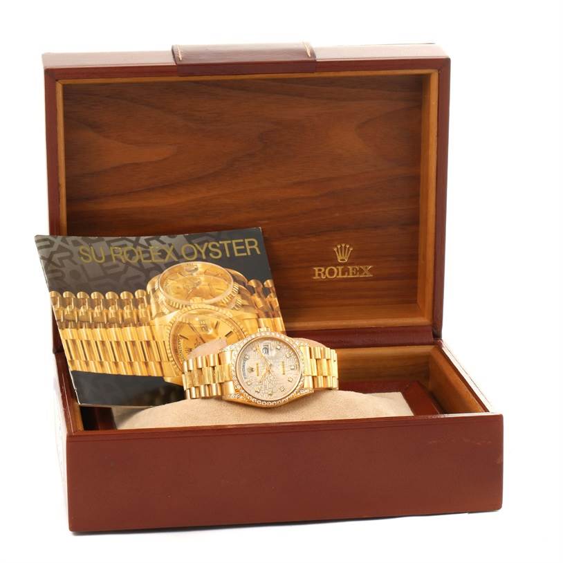 The image shows a Rolex President 18138 Men
s Yellow Gold Silver Dial 18138 Men
s Yellow Gold Silver Dial model watch and its accessories, including a booklet, displayed in an open wooden box.