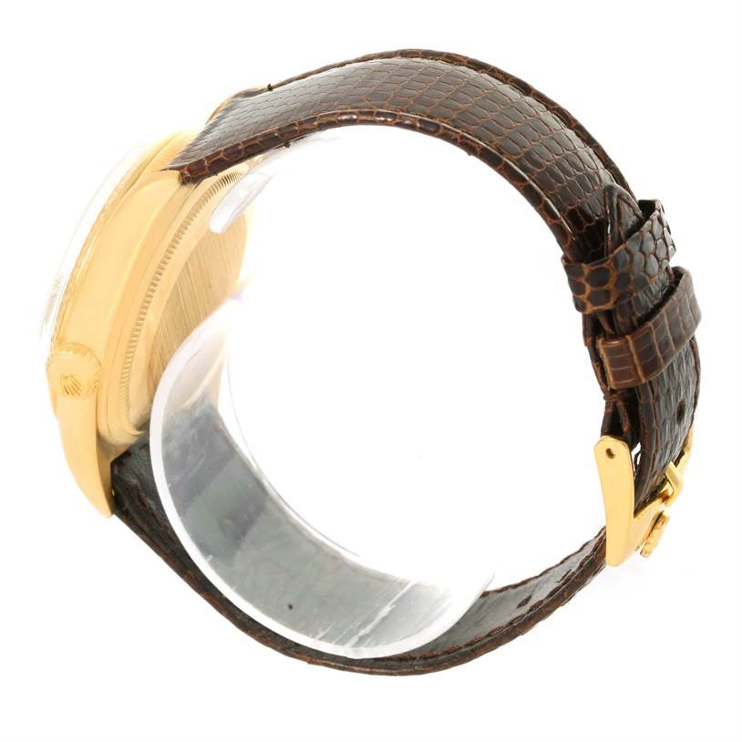 The image shows a side view of a Rolex President 1803 Men
s Yellow Gold Silver Dial 1803 Men
s Yellow Gold Silver Dial model watch, highlighting its gold case, crown, and brown leather strap with buckle.