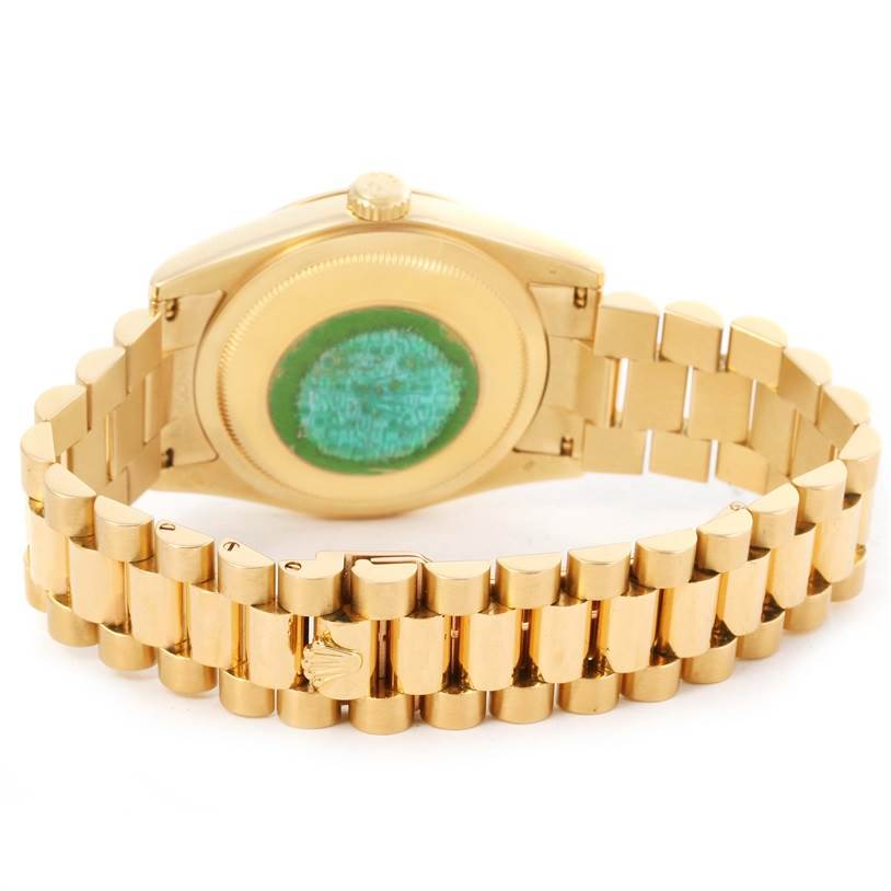 This image shows the back and bracelet of a Rolex President 118208 Men
s Yellow Gold White Dial 118208 Men
s Yellow Gold White Dial model watch, focusing on the case back and signature links.