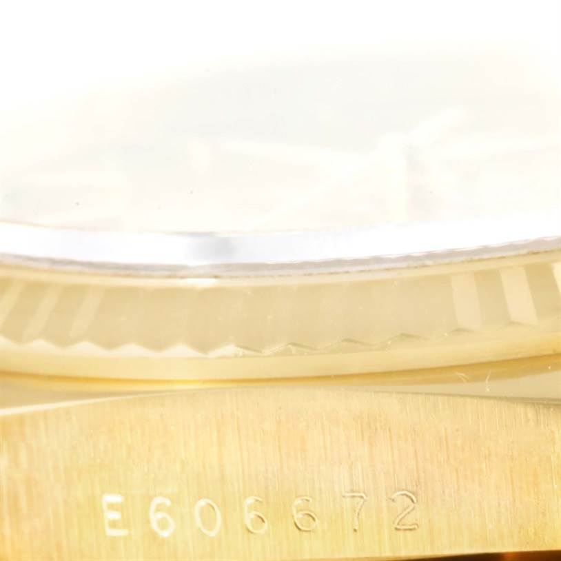 The image shows a close-up of the Rolex President 18238 Men
s Yellow Gold Champagne Dial 18238 Men
s Yellow Gold Champagne Dial model watch, focusing on the bezel and part of the case with a visible serial number.