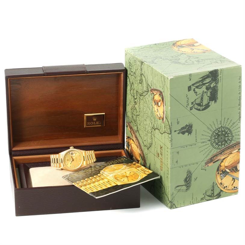 This image shows a Rolex President 18038 Men
s Yellow Gold Champagne Dial 18038 Men
s Yellow Gold Champagne Dial model watch in an open wooden box with its green outer packaging and a booklet.