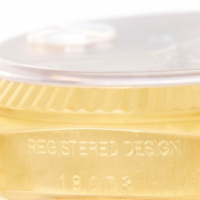 This close-up image of the Rolex President 18038 Men
s Yellow Gold Champagne Dial 18038 Men
s Yellow Gold Champagne Dial model displays the engraved bezel and part of the crystal from a side angle.