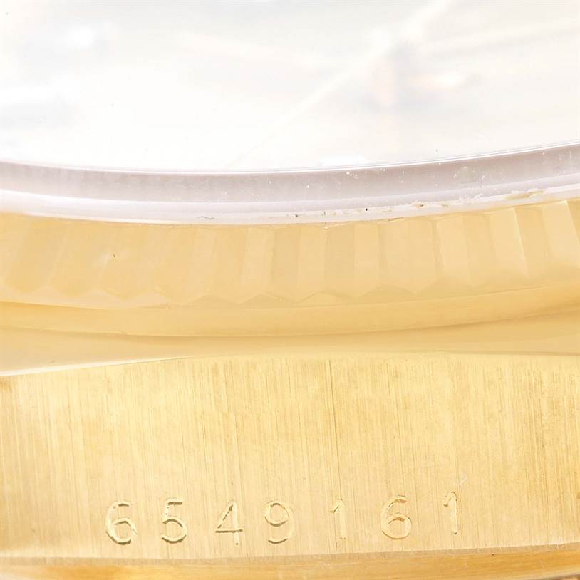 This image shows a close-up view of the gold bezel and serial number engraving on a Rolex President 18038 Men
s Yellow Gold Champagne Dial 18038 Men
s Yellow Gold Champagne Dial model watch.