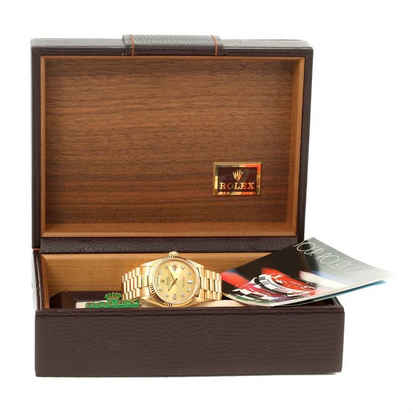 The image shows the Rolex President 18038 Men
s Yellow Gold Champagne Dial 18038 Men
s Yellow Gold Champagne Dial model watch inside its open wooden box with an accompanying booklet.