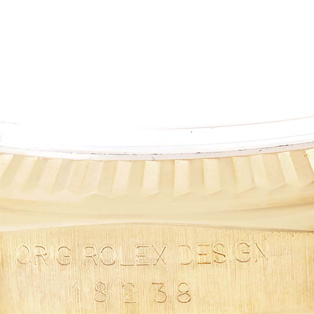 This close-up image of a Rolex President 18238 Men
s Yellow Gold Beige Dial 18238 Men
s Yellow Gold Beige Dial model shows the engraved serial number and part of the fluted bezel.