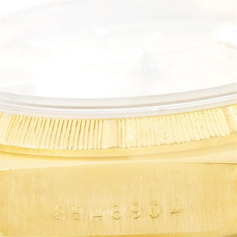 This image shows a close-up view of the Rolex President 18078 Men
s Yellow Gold Champagne Dial 18078 Men
s Yellow Gold Champagne Dial model
s gold case edge and fluted bezel with the serial number visible.