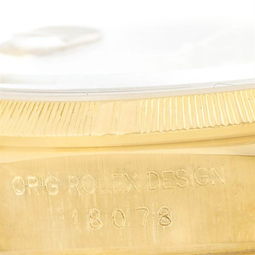 This close-up shows the side view of the gold casing and part of the bezel of a Rolex President 18078 Men
s Yellow Gold Champagne Dial 18078 Men
s Yellow Gold Champagne Dial watch, highlighting the engraving.