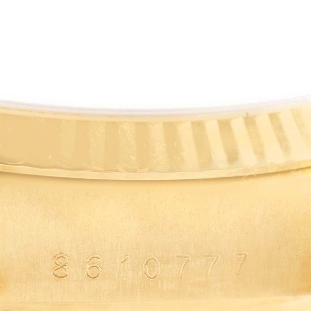 This close-up image shows the serial number and part of the fluted bezel of a Rolex President 18038 Men
s Yellow Gold Black Dial 18038 Men
s Yellow Gold Black Dial watch.