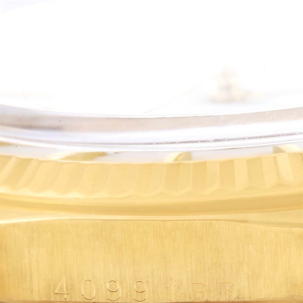This close-up image shows the side of a Rolex President 1601 Men
s Yellow Gold White Dial 1601 Men
s Yellow Gold White Dial model watch, highlighting the serial number and part of the crystal and case.