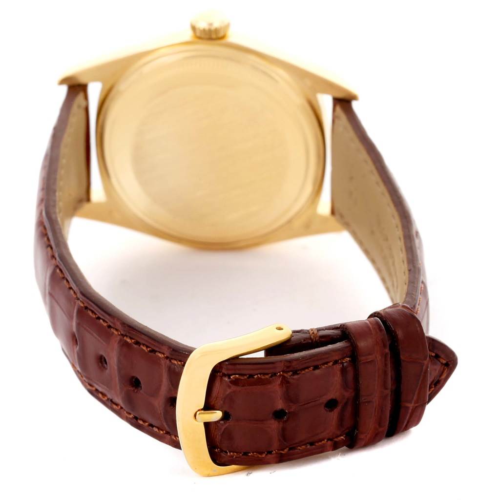This image shows the back of the Rolex President 1601 Men
s Yellow Gold White Dial 1601 Men
s Yellow Gold White Dial model watch, focusing on its case and brown leather strap with a gold buckle.