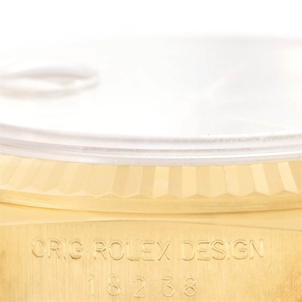 This image shows a close-up angle of the bezel, crystal, and part of the case of a Rolex President 18238 Men
s Yellow Gold Champagne Dial 18238 Men
s Yellow Gold Champagne Dial model watch, with engraved text.