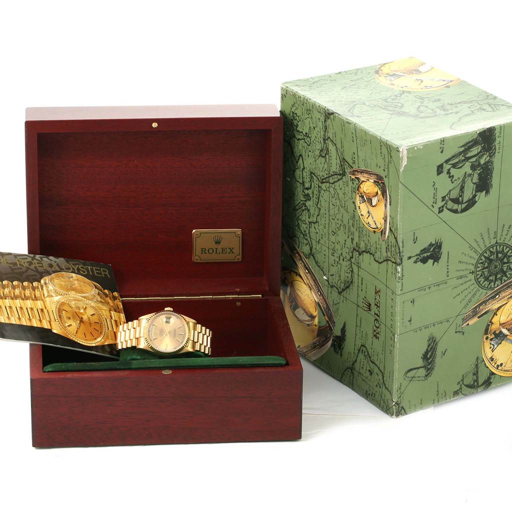 The image shows a Rolex President 18238 Men
s Yellow Gold Champagne Dial 18238 Men
s Yellow Gold Champagne Dial model watch inside a wooden box, next to a green decorative outer box.