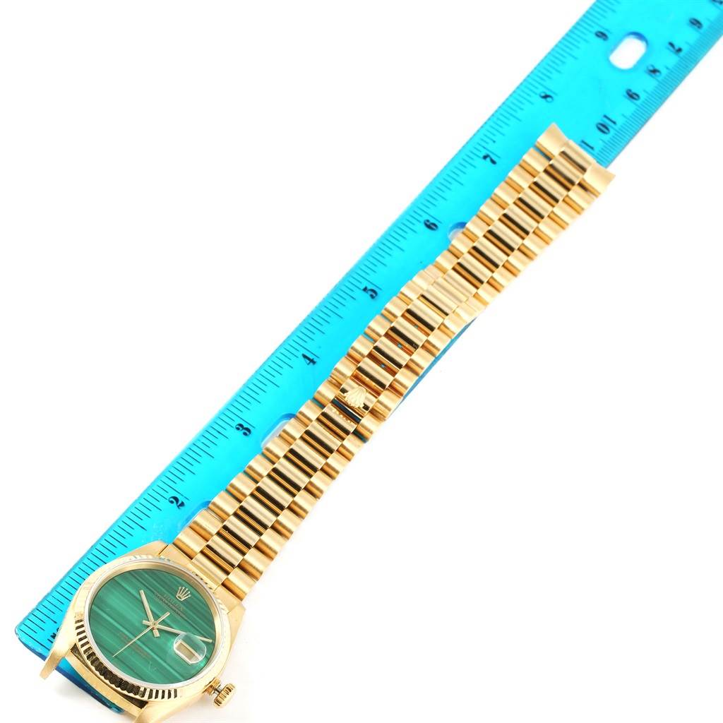 The image shows a Rolex President 16238 Men's Yellow Gold Green Dial 16238 Men's Yellow Gold Green Dial watch with its face and entire bracelet, alongside a blue measuring ruler.