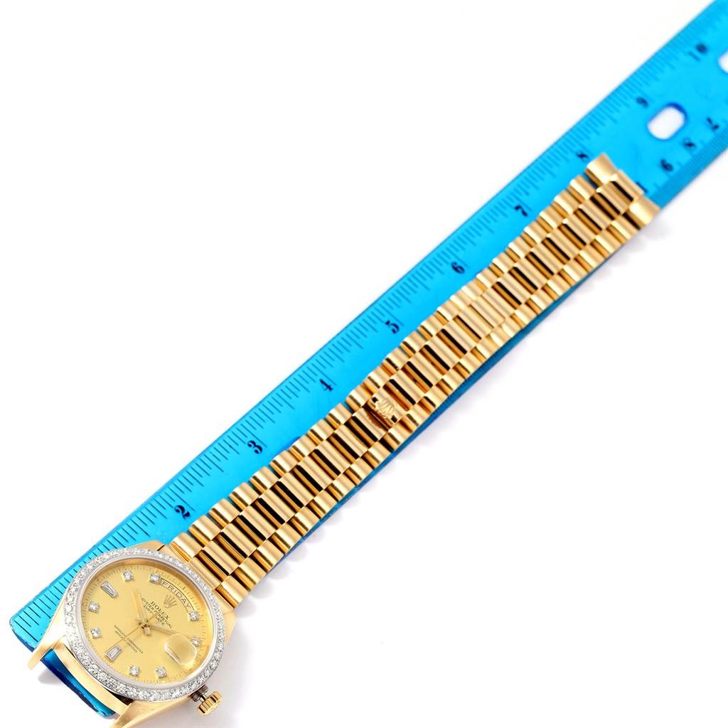 The image shows a top-down view of a Rolex President 18048 Men
s Yellow Gold Champagne Dial 18048 Men
s Yellow Gold Champagne Dial model watch, highlighting its face, bezel, and bracelet alongside a blue ruler.