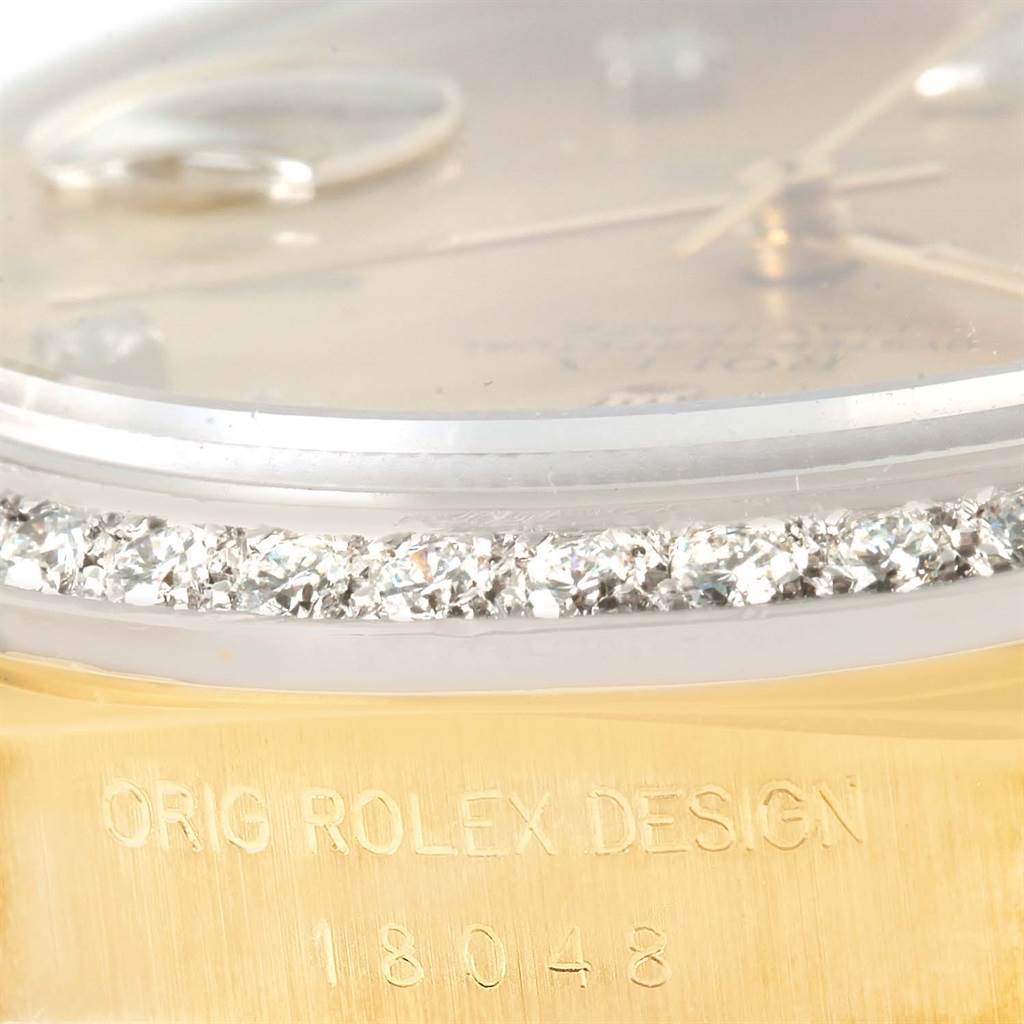 This close-up angle of the Rolex President 18048 Men
s Yellow Gold Champagne Dial 18048 Men
s Yellow Gold Champagne Dial model showcases part of the dial, crystal, diamonds, and "ORIG ROLEX DESIGN" with reference number 18048.