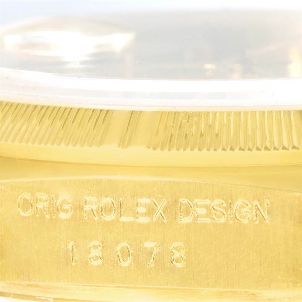 This close-up image shows the side view of a Rolex President 18078 Men
s Yellow Gold Champagne Dial 18078 Men
s Yellow Gold Champagne Dial watch, highlighting its bezel and engraved serial number.