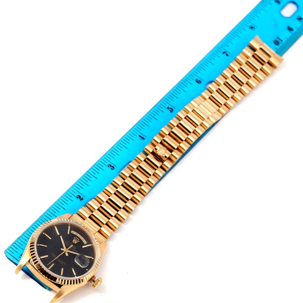The image shows a Rolex President 18238 Men's Yellow Gold Black Dial 18238 Men's Yellow Gold Black Dial model watch laid flat, alongside a ruler for scale, illustrating the case, bracelet, and clasp.