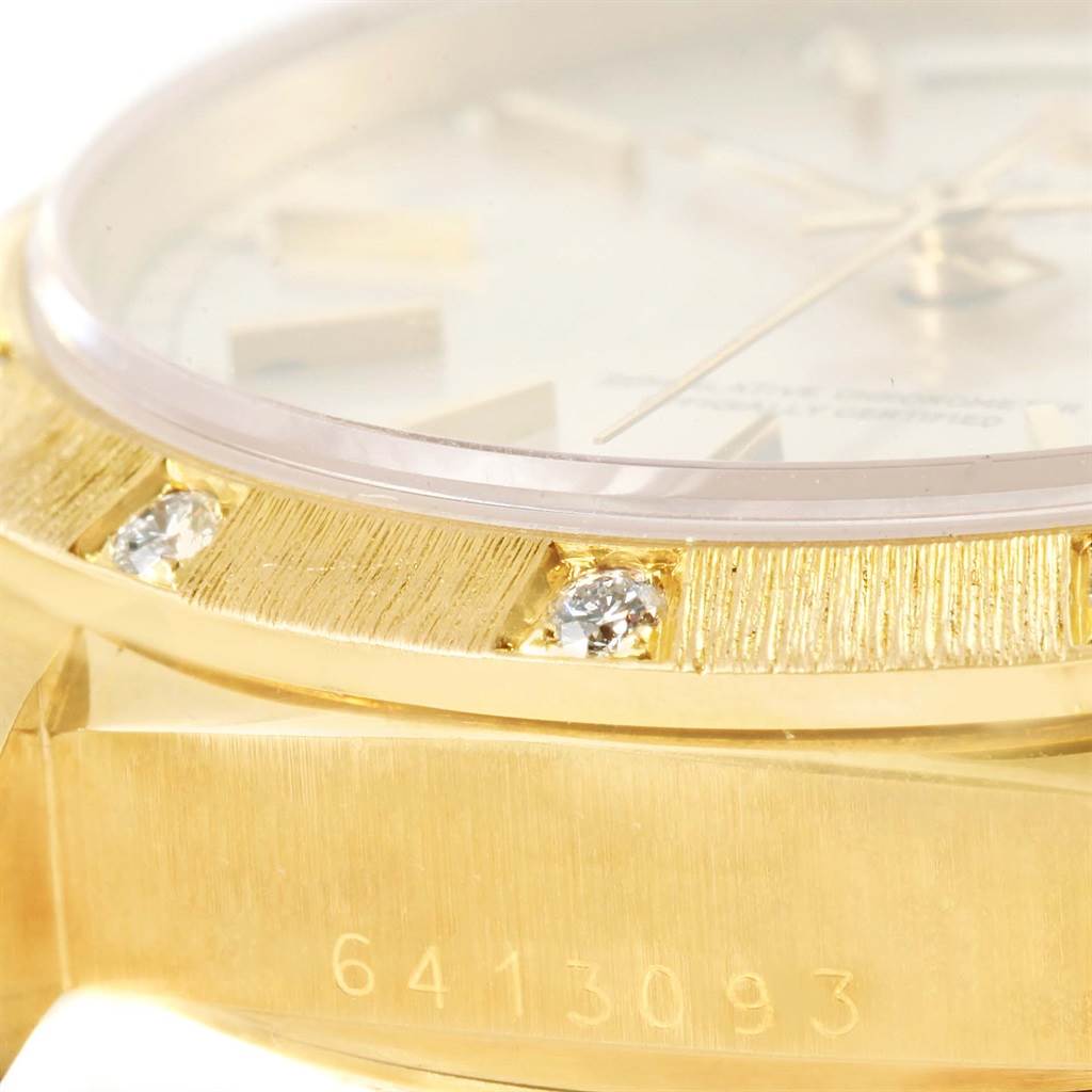 This close-up angle of a Rolex President 18078 Men
s Yellow Gold Silver Dial 18078 Men
s Yellow Gold Silver Dial watch shows the bezel, diamonds, part of the dial, and case number.