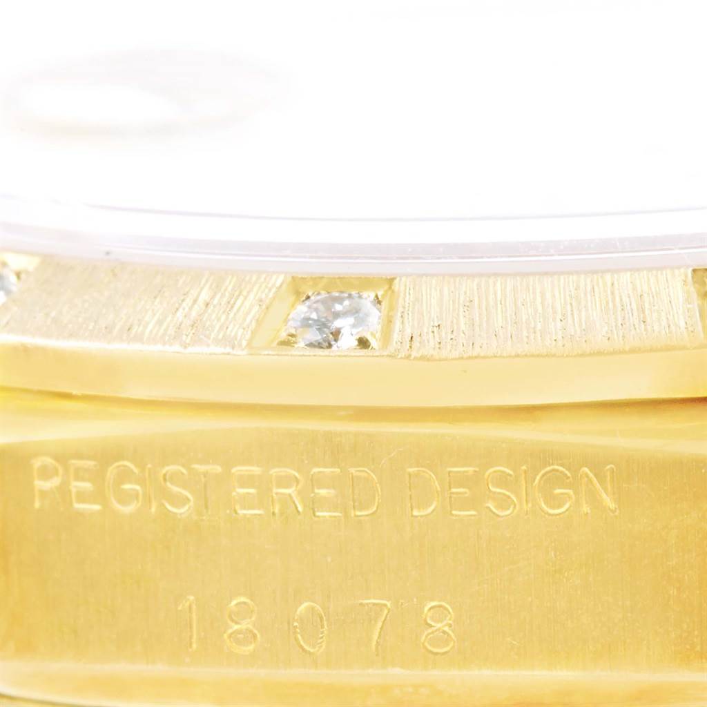 Close-up of the side of a Rolex President 18078 Men
s Yellow Gold Silver Dial 18078 Men
s Yellow Gold Silver Dial watch, displaying the edge of the bezel, diamonds, and engraved model number.