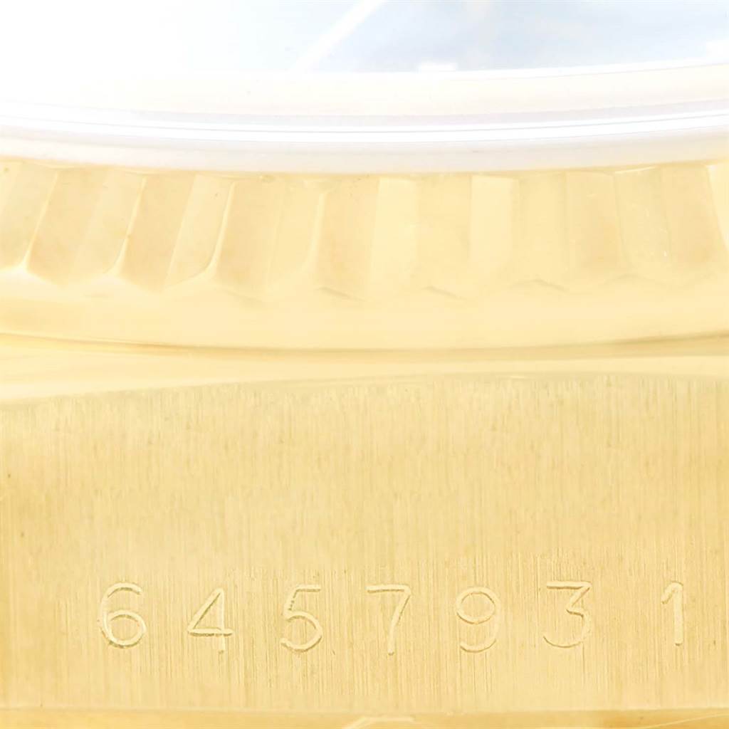 This image shows a close-up of the serial number and part of the bezel of a Rolex President 18038 Men
s Yellow Gold Blue Dial 18038 Men
s Yellow Gold Blue Dial model watch.