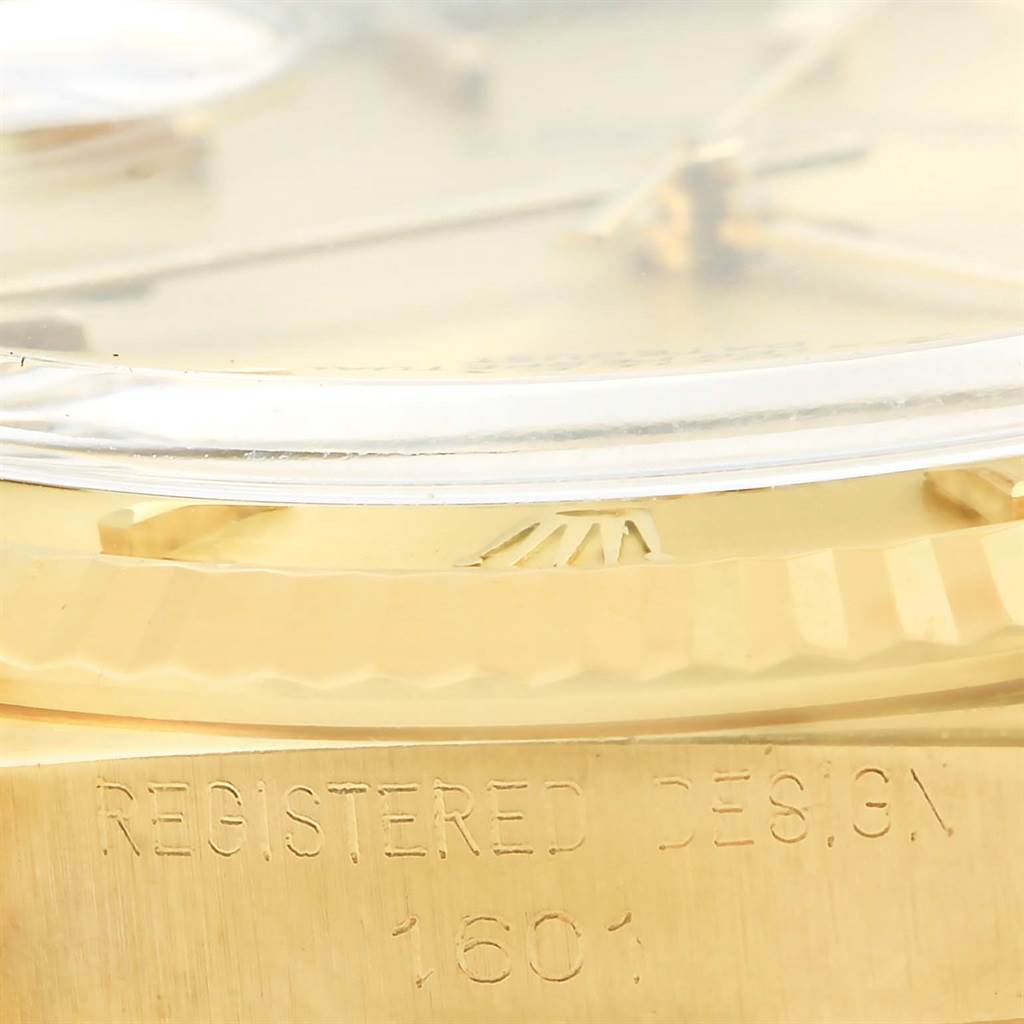 This image shows a close-up of the side of a Rolex President 1601 Men's Yellow Gold Champagne Dial 1601 Men's Yellow Gold Champagne Dial model watch, focusing on the bezel, crystal, and engraving.