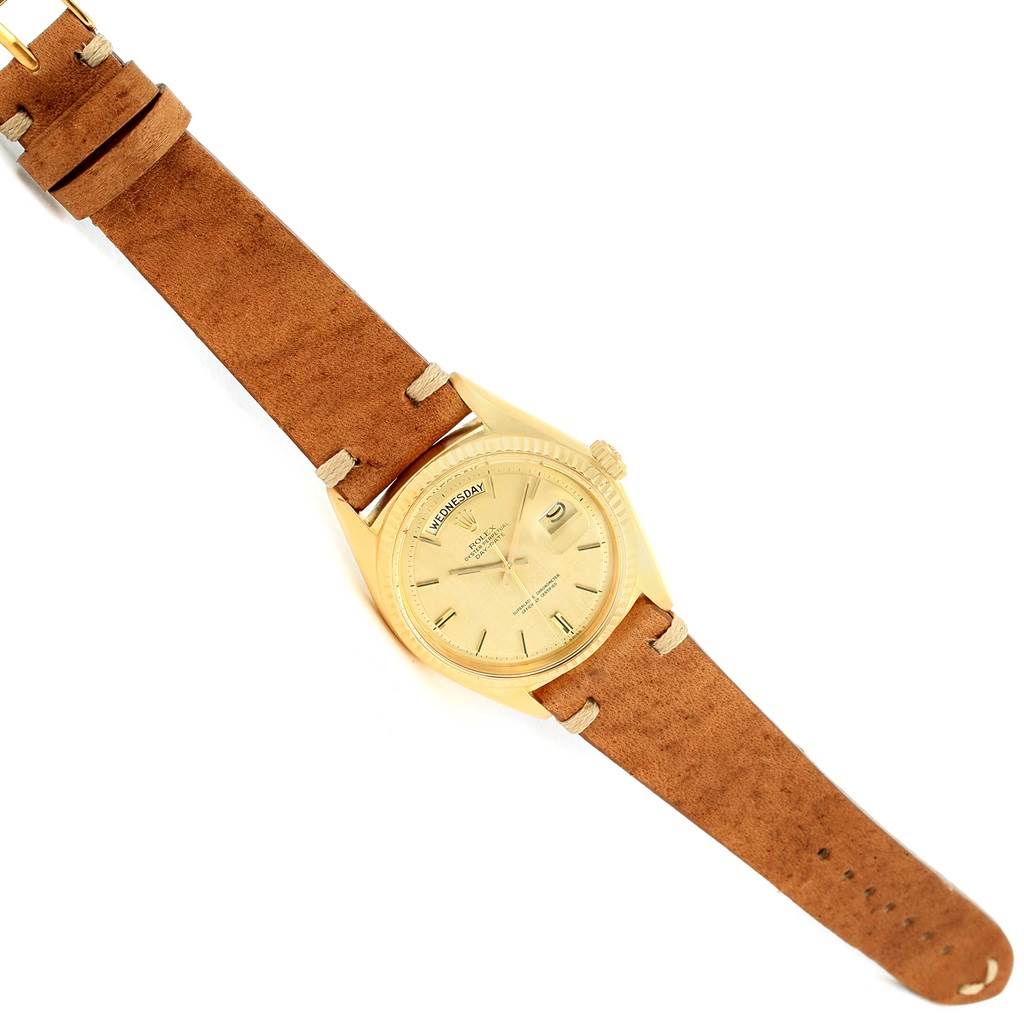 The image shows a Rolex President 1803 Men
s Yellow Gold Champagne Dial 1803 Men
s Yellow Gold Champagne Dial model watch from a top-down angle, featuring its dial, bezel, and leather strap.