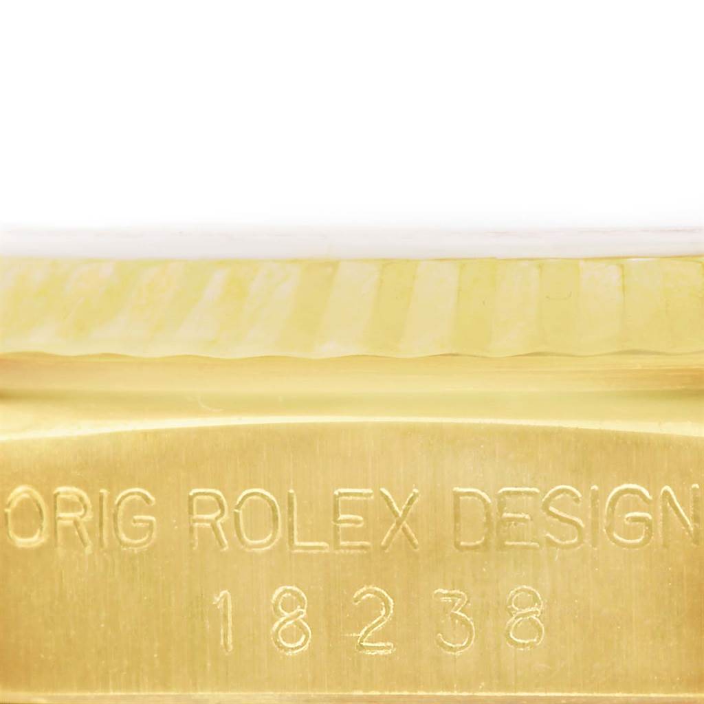 The image shows a close-up of the case side of the Rolex President 18238 Men
s Yellow Gold Black Dial 18238 Men
s Yellow Gold Black Dial model watch, specifically the engraving "ORIG ROLEX DESIGN 18238."