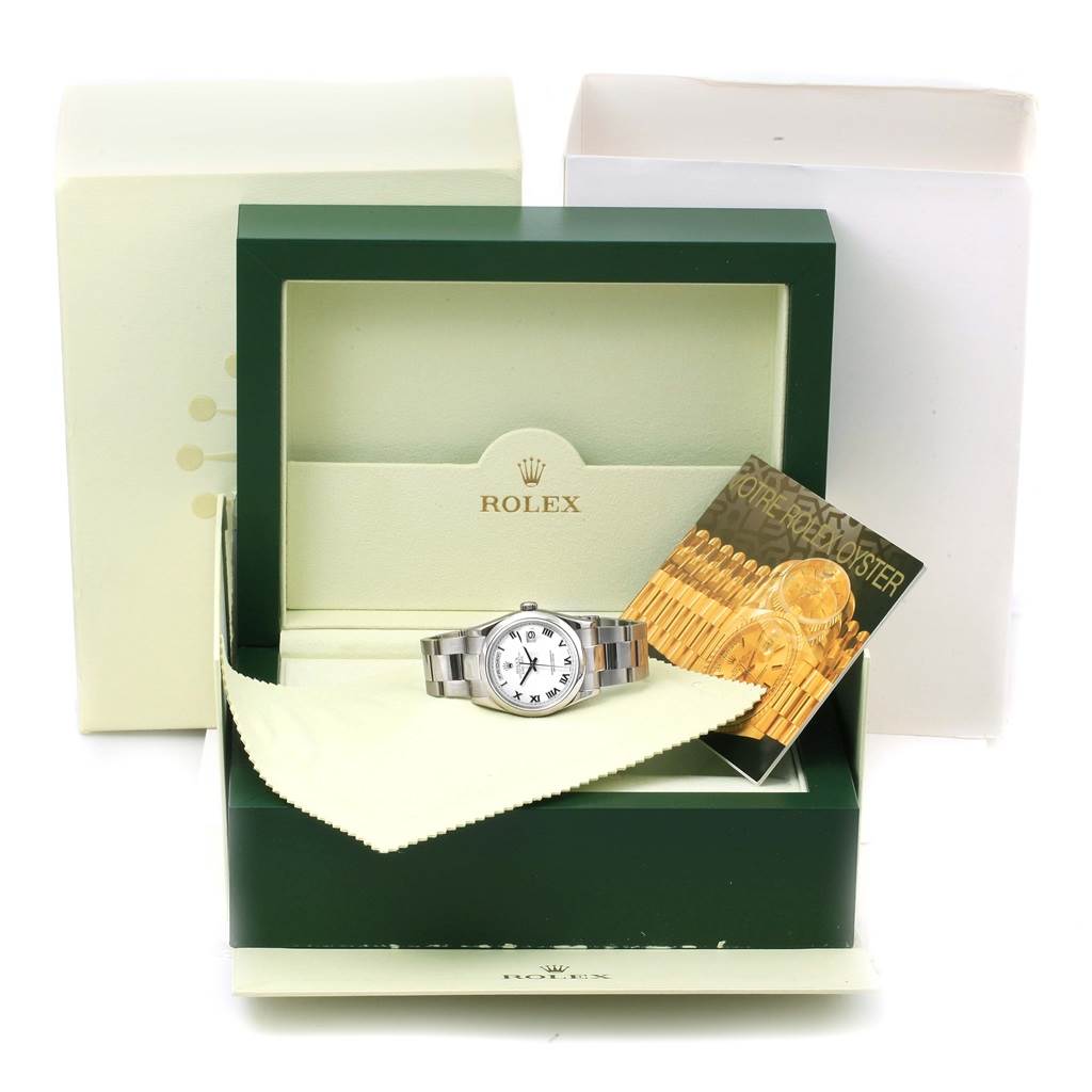 The image shows a Rolex President 118209 Men's White Gold White Dial 118209 Men's White Gold White Dial watch placed inside its green and cream presentation box, alongside a brochure.