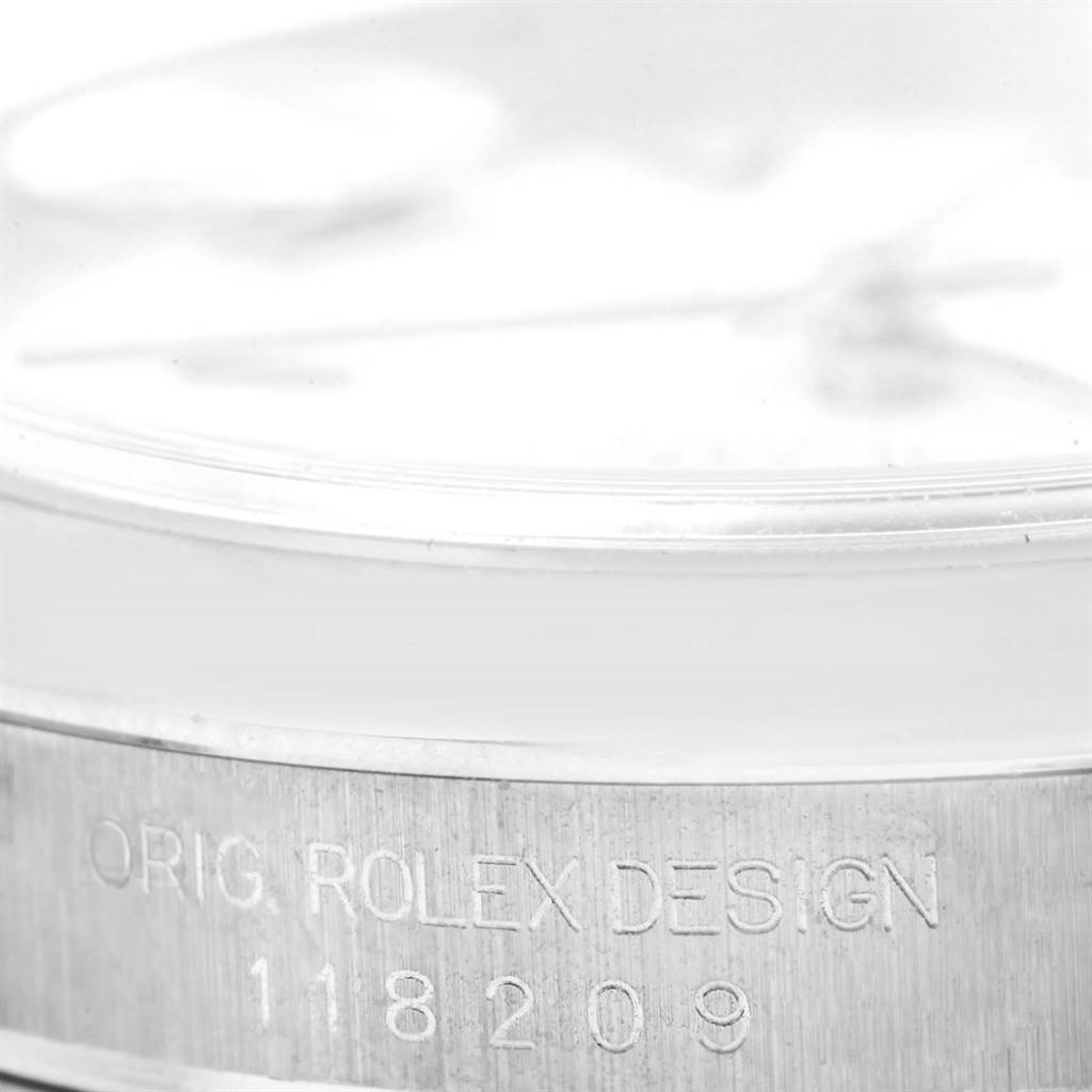 This close-up image shows the side of a Rolex President 118209 Men's White Gold White Dial 118209 Men's White Gold White Dial model watch, focusing on its engraved original Rolex design and model number.