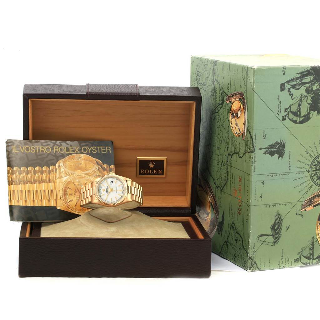The image shows a Rolex President 18238 Men
s Yellow Gold White Dial 18238 Men
s Yellow Gold White Dial watch with its box, booklet, and additional packaging, viewed from the front.